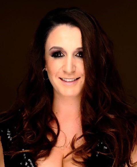 Headshot of smiling white woman with long, dark hair and eyeshadow.