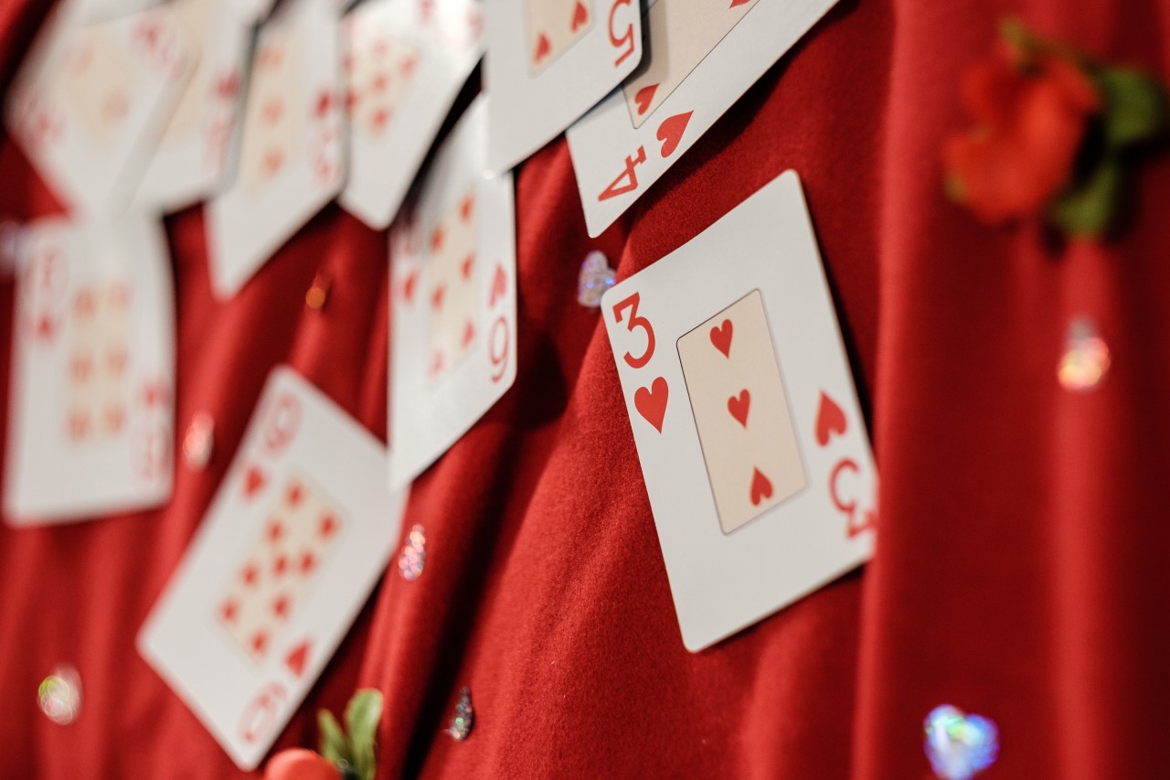 Photo of playing cards - all hearts - on a red satin backdrop