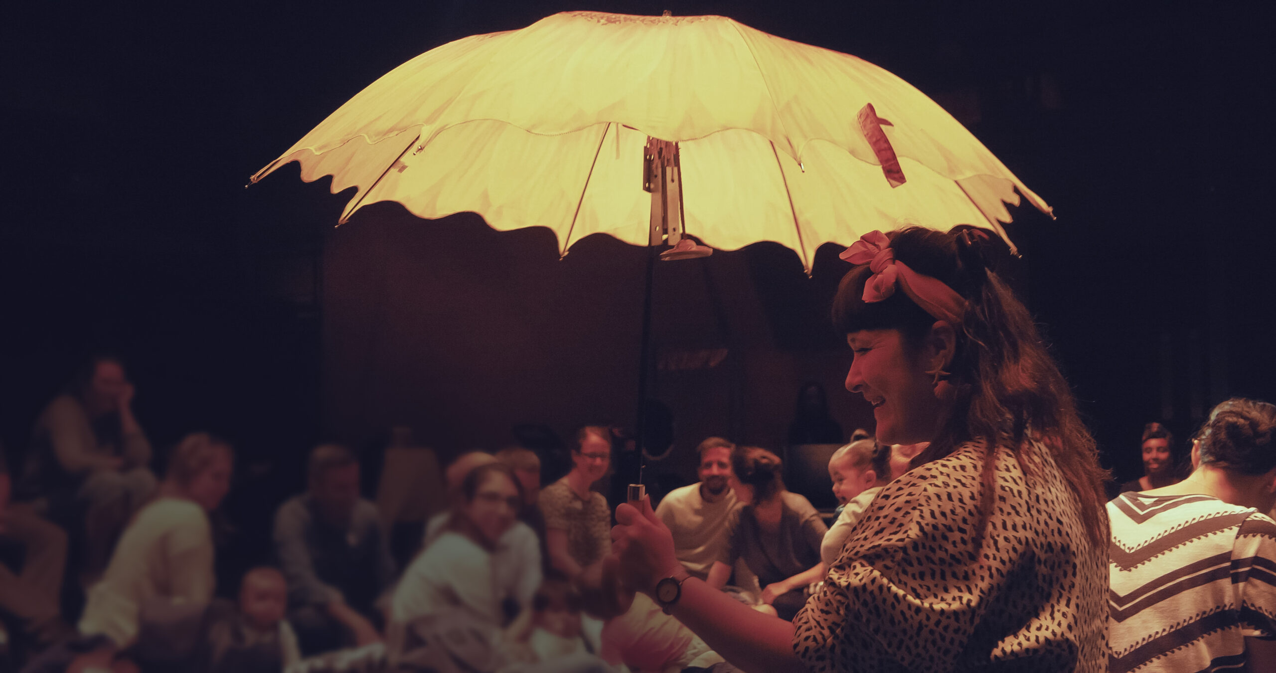 In image of a person holding a yellow umbrella infront of a crowd.